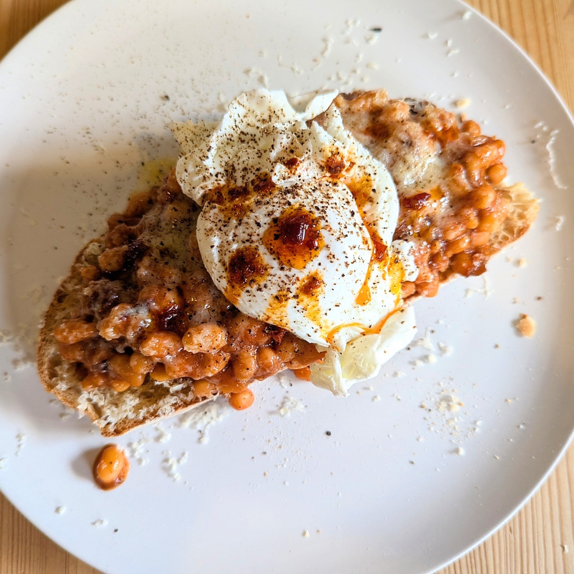 Plated dish with a breaded item topped with a creamy sauce on a wooden surface